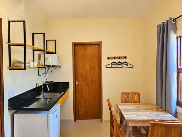 Cozinha compacta e mesa de refeições do Quarto Premium do Ilha Flat Hotel