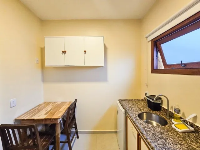 Mesa de refeições e cozinha do Quarto Standard Double do Ilha Flat Hotel