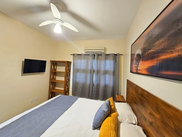Quarto com cama, televisão e ar-condicionado do Standard Double do Ilha Flat Hotel