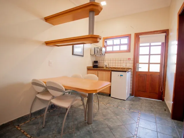 Mesa de refeições e cozinha compacta do Quarto Standard do Ilha Flat Hotel
