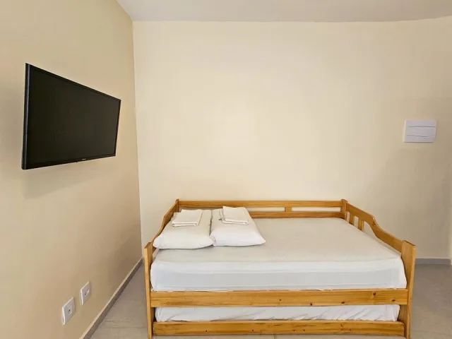 Sofá-cama e televisão do Quarto Deluxe Hidromassagem 5205 do Ilha Flat Hotel