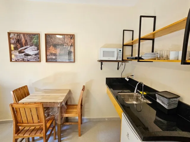 Mesa de refeições e cozinha do Quarto Deluxe Hidromassagem 5204 do Ilha Flat Hotel