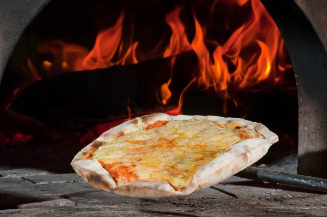 Pizza assando no forno a lenha