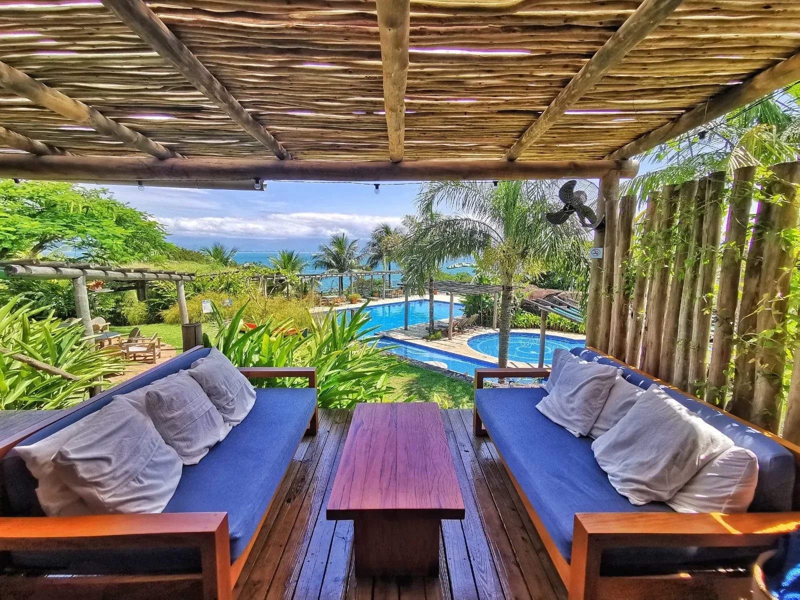 Varanda com vista para a piscina e o mar na Pousada Armação dos Ventos