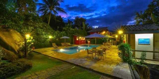 Pátio e piscina ao entardecer na Guarubela Villa Vittoria
