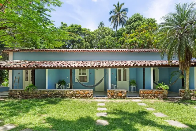 Suítes azuis com varandas e redes entre os jardins da Vila Siriúba